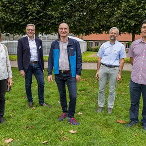 Fünf Mitglieder der Themenwerkstatt Energieversorgung stehen auf einer Grasfläche im Botanischen Garten.