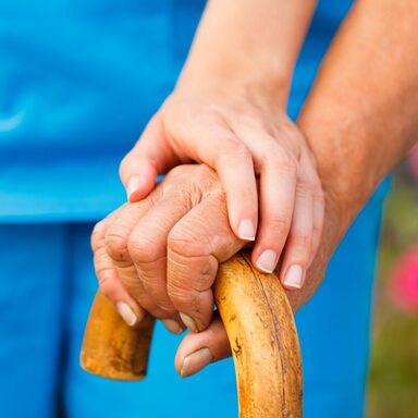 Helfende Hand für älteren Menschen mit Spazierstock