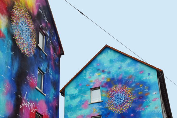 Zwei bemalte Häuserwände mit bunten Farben ohne konkretes Motiv