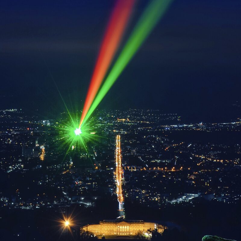 Roter und grüner Laserstrahl vom Fridericianum zum Herkules über dem nächtlichen Kassel