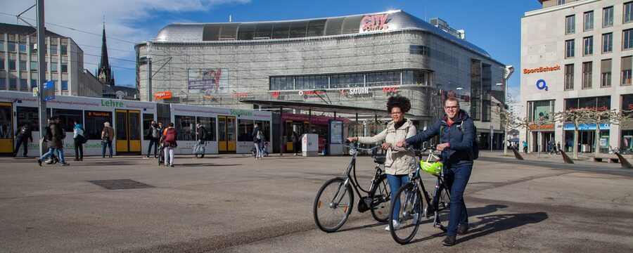 Zwei Fahrradfahrer, die auf dem Königsplatz in Kassel ihre Fahrräder schieben