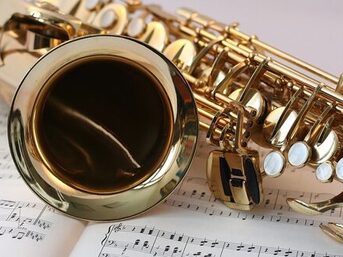 Ein Saxophon liegt auf Musiknoten