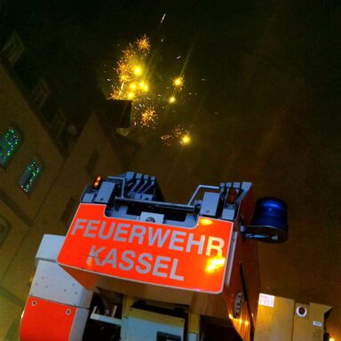 Einsatzwagen der Feuerwehr Kassel mit Feuerwerk im Hintergrund