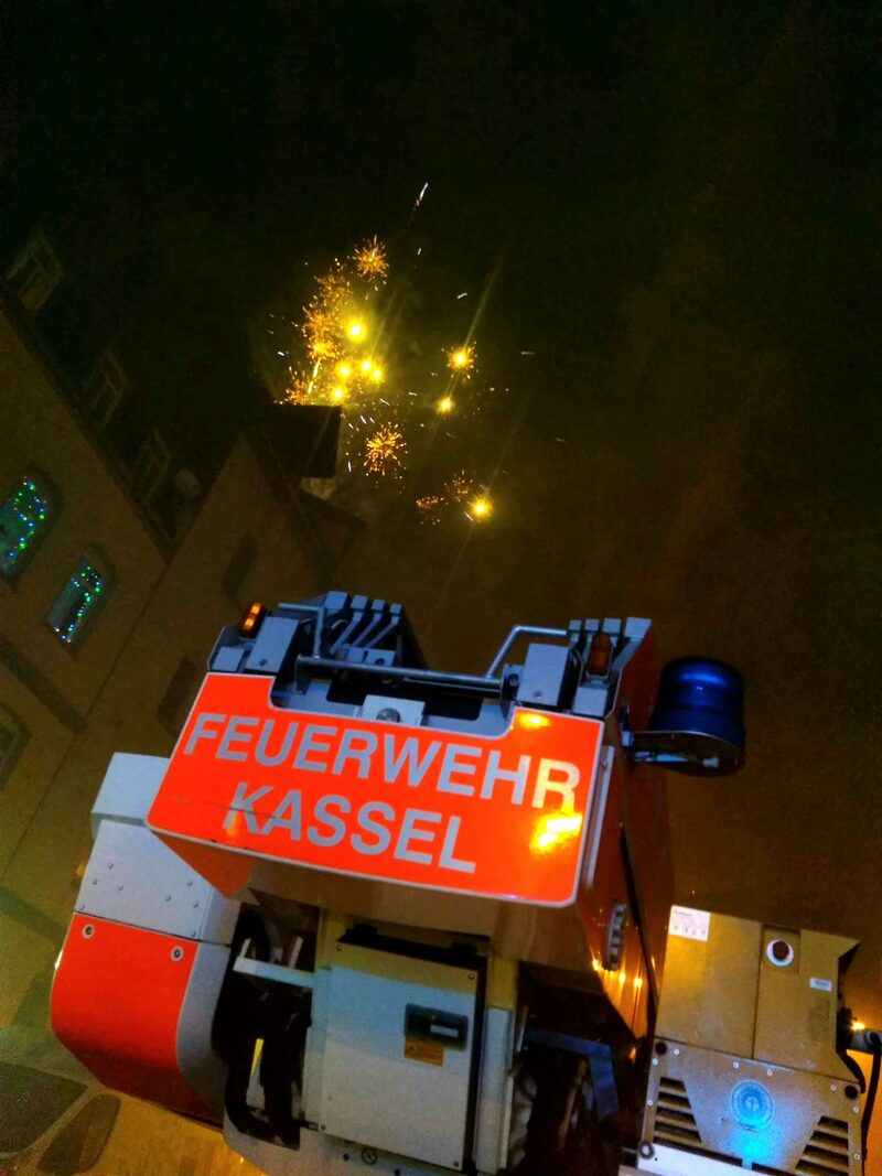 Einsatzwagen der Feuerwehr Kassel mit Feuerwerk im Hintergrund