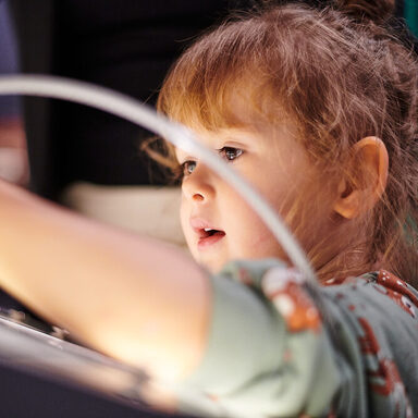 Ein kleines Kind spielt auf einem Leuchtbildschirm
