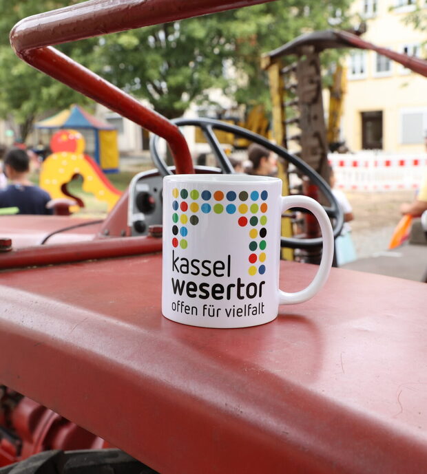 Eine Tasse mit der Aufschrift "Kassel Wesertor" steht auf einem Trecker