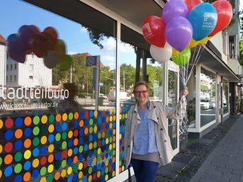Frau mit Luftballons vor dem Stadtteilbüro