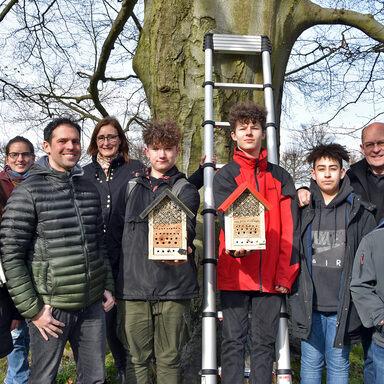 Schülerinnen und Schüler aus Kassel hängen Nistkästen auf