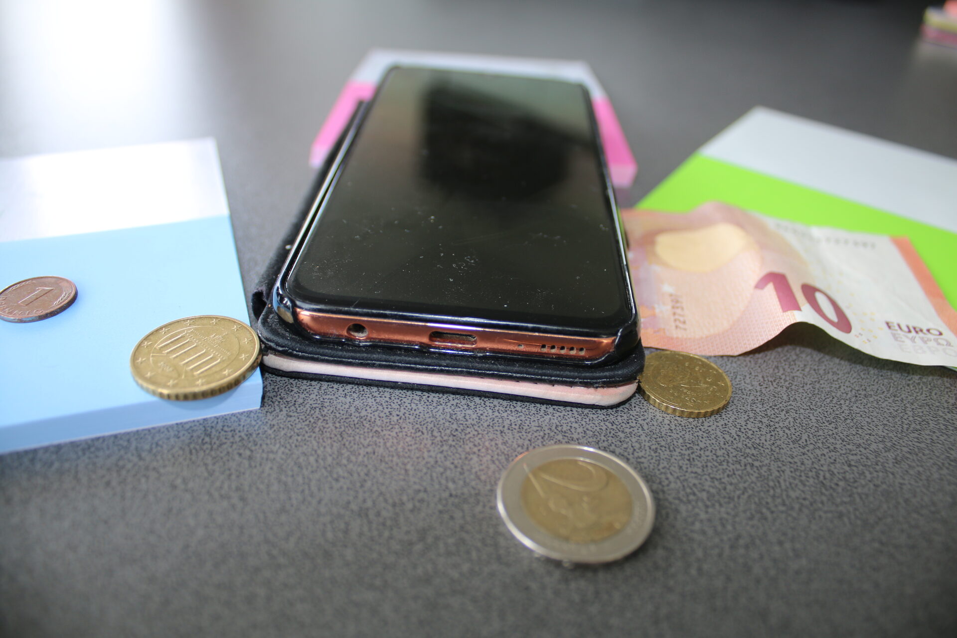 Handy mit Geldschein und Münzen