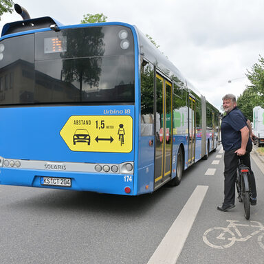 Ein Bus steht neben einem Fahrradfahrer