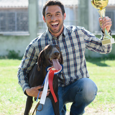 Mann mit Hund und Pokal
